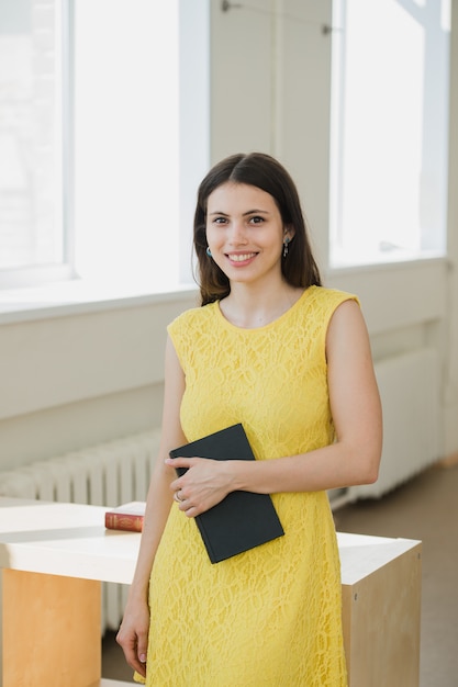 Happy young smiling student girl with book.