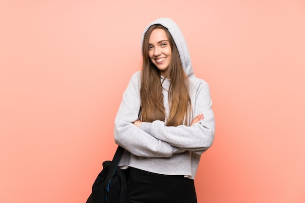 Giovane donna felice di sport sopra fondo rosa isolato