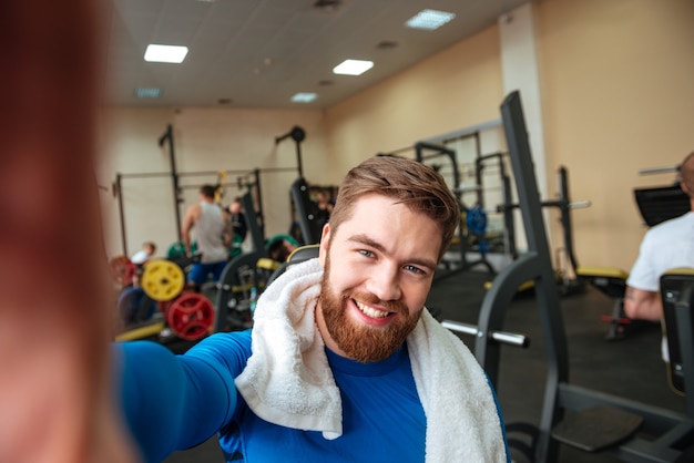 Happy young sportsman with towel make selfie.