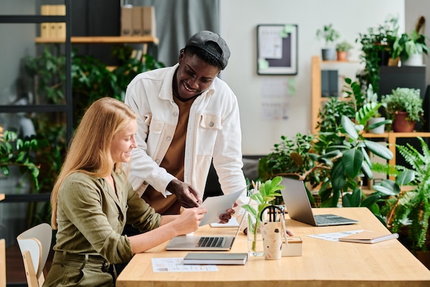 Photo happy young successful colleagues discussing financial data in front of laptop