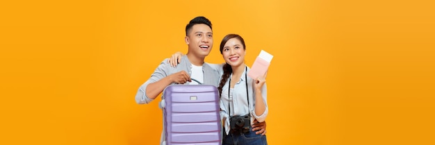 Happy young tourists couple friends man woman isolated on yellow background