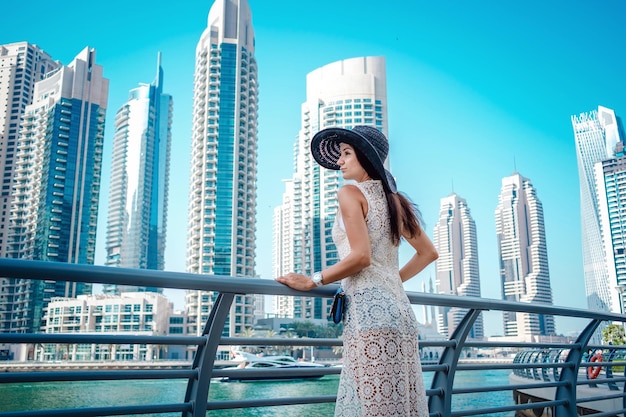 Happy young traveler woman in big city Dubai Luxury travel vacation Woman looking at view Dubai marina