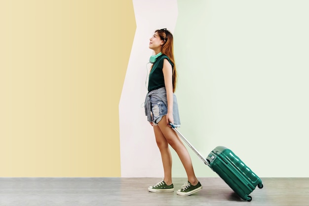 Happy Young Traveler Woman Walking with Suitcase and Music Headphone