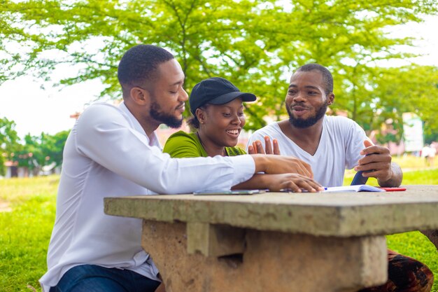 Happy young university students studying with books in the campus