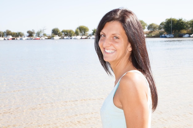 Happy young woman on beach and looking on copy space