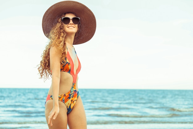 Счастливая молодая женщина на пляже в летние каникулы.