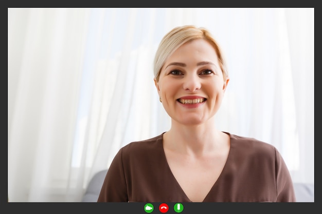 Photo happy young woman blogger applicant teacher sit at home office look at camera doing online job interview during video chat conference call record vlog teaching on webinar in app, webcam view