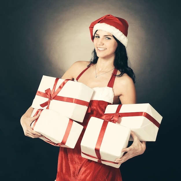 Happy young woman in costume of Santa Claus with lots of Christmas shopping