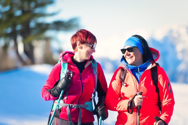 雪のハイキング中に幸せな若い女性のカップル