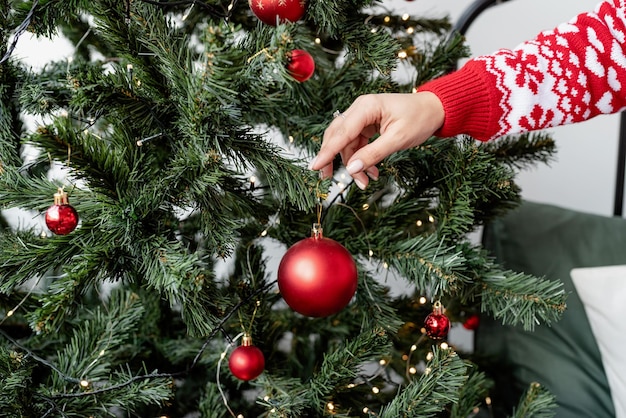 Happy young woman decorating christmas tree