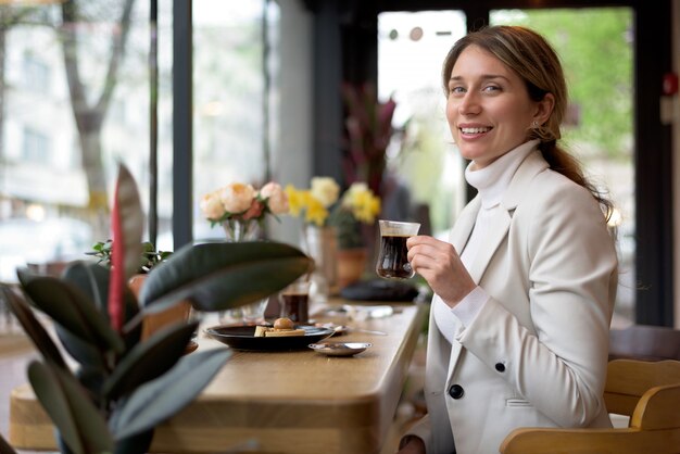 Giovane donna felice che beve caffè