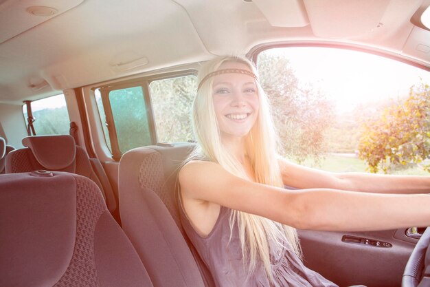 Happy young woman driving car