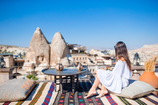 Felice giovane donna durante le vacanze guardando le mongolfiere in cappadocia turchia