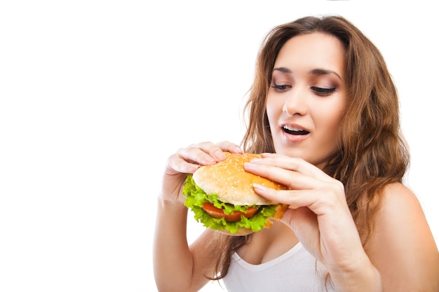 Happy Young Woman Eating big yummy Burger isolated on white background