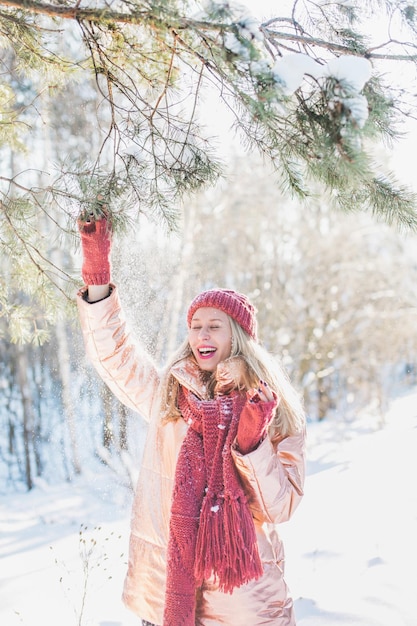 happy young woman enjoying by trees on snowy field in winter