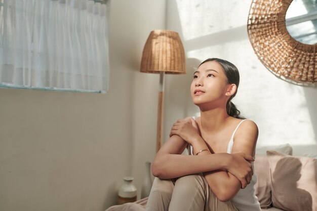 Photo happy young woman enjoying sunny morning on the bed