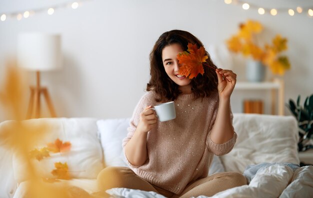 행복한 젊은 여성이 침대에서  ⁇ 은 아침을 즐기고 있습니다.