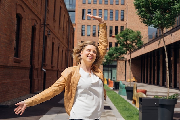 Happy young woman enjoys life in city in spring while traveling life is wonderful tourism and pleasu...