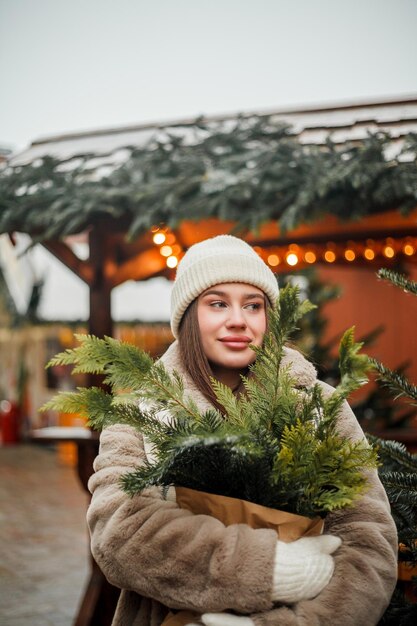 Foto felice giovane donna di aspetto europeo al mercato di natale in germania decorazione della città festiva capodanno vacanze invernali