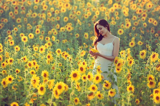 Happy young woman in a field of sunflowers