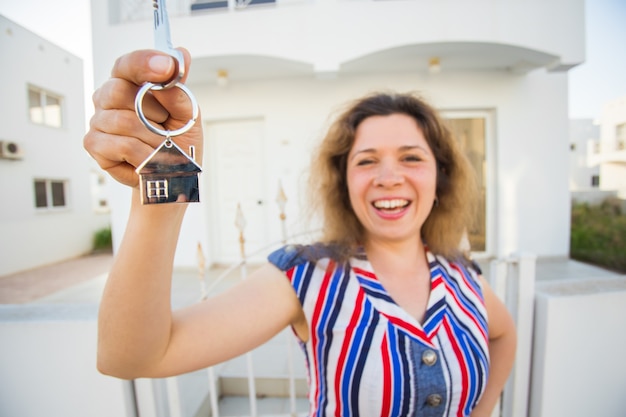 새 집 열쇠와 새 집 앞에서 행복 한 젊은 여자