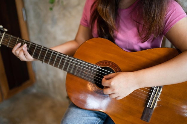 写真 幸せな若い女性の手がアコースティック ギターを演奏