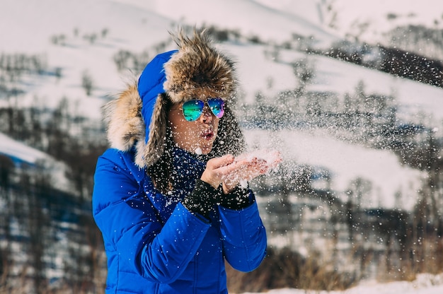 Happy young woman have fun and enjoy fresh snow at beautiful winter day