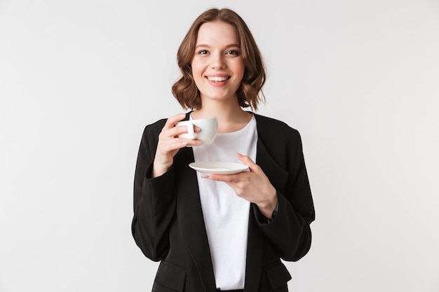 Happy young woman holding cup of coffee.