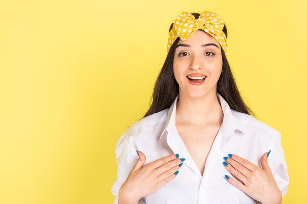 Happy young woman holding her hands to her chest and smiling