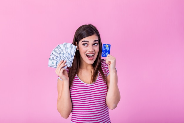 счастливая молодая женщина, держащая деньги и кредитную карту.