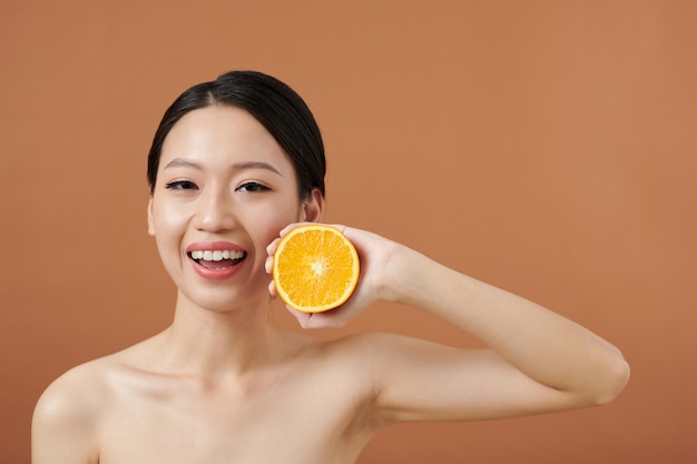 Happy Young Woman Holding Orange