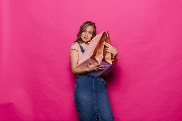 Happy young woman hugging her shopping bags smiling and looking at the camera