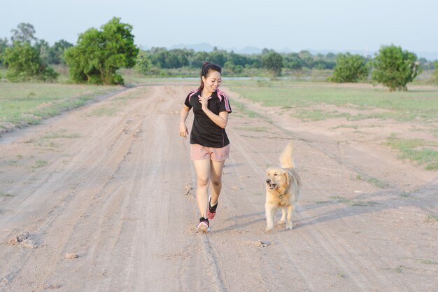 Happy young woman jogging with her beagle dog