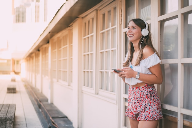 携帯電話で音楽を聞いて幸せな若い女