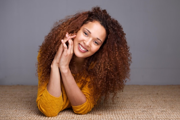 Photo happy young woman lying on floor