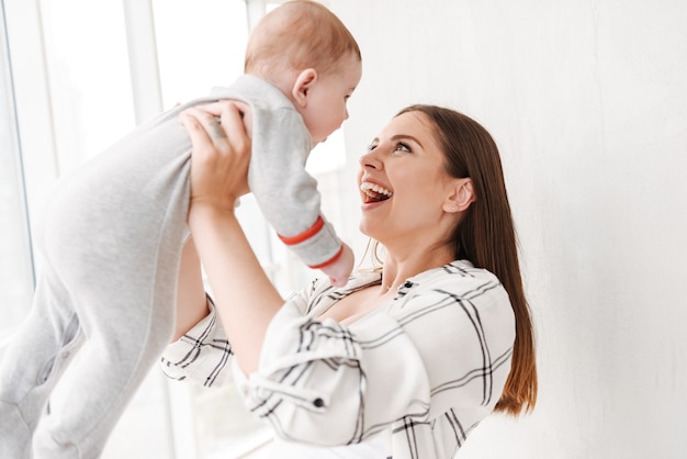 Happy young woman mother holding in hands her little son