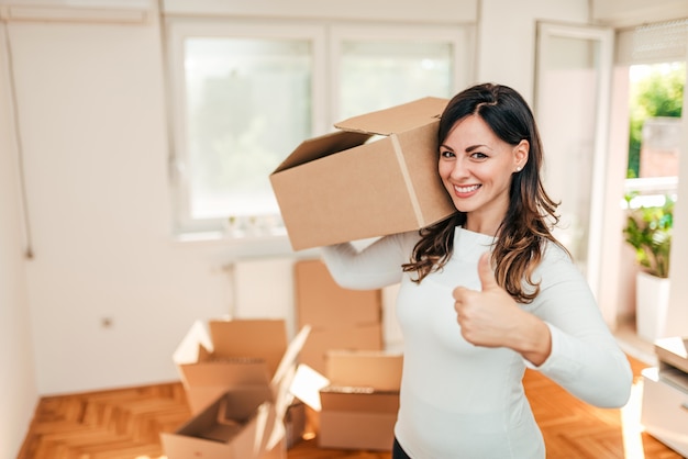 Happy young woman moving to a new home.