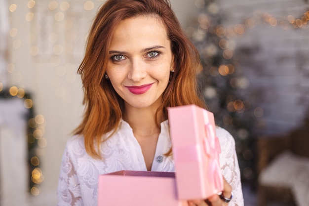 Happy young woman opening a Christmas present box