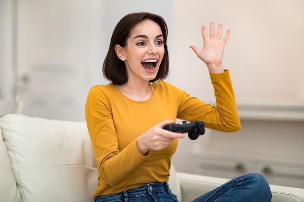 家でビデオゲームをする幸せな若い女性