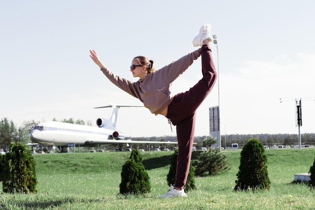 Foto felice giovane donna in posa come aereo