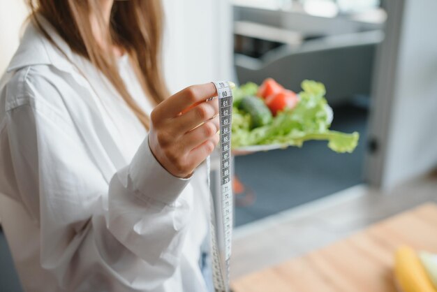 Happy young woman preparing salad in kitchen Healthy diet