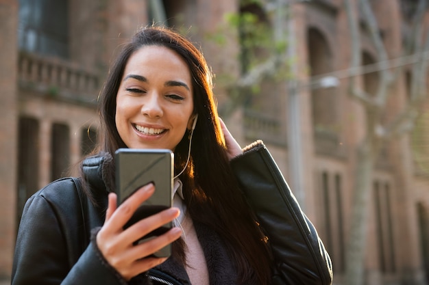 Happy young woman reading a message at her phone