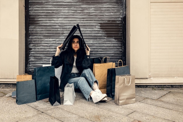 Foto felice giovane donna gioisce nel buon shopping ragazza con borse della spesa