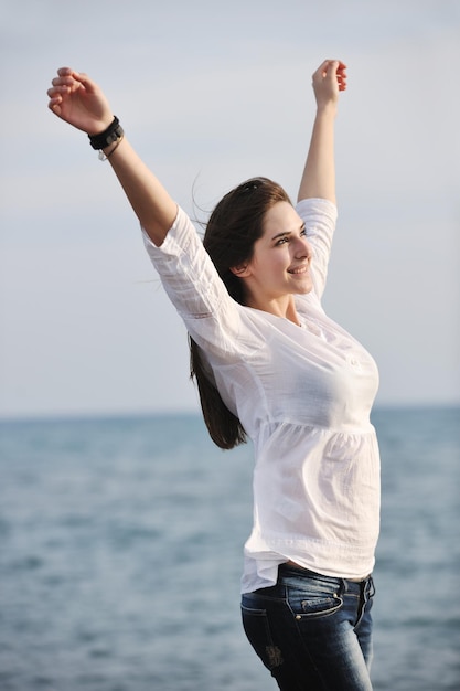 happy young woman relax on beautiful  beach at fresh summer morning and enjoy first ray of sun