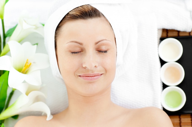 Happy young woman resting on a massage table 