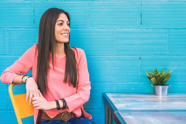 Happy young woman seating in a restaurant