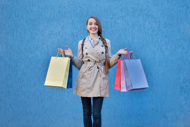 カラフルなバッグを持つ幸せな若い女性中毒者。