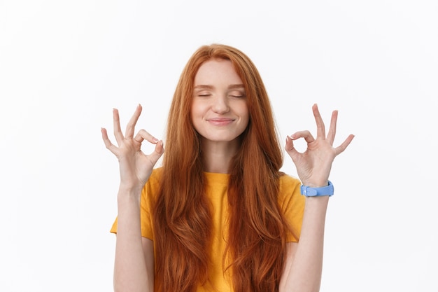 Happy young woman showing ok sign with fingers and winking