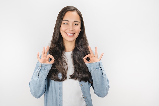 Happy young woman showing ok sign with hands isolated on white background