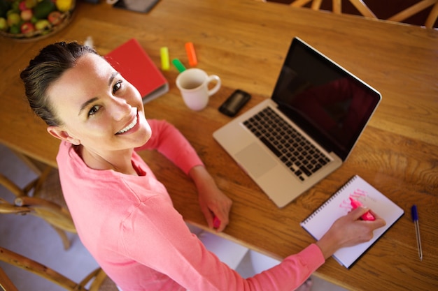 Happy young woman sitting at her work desk